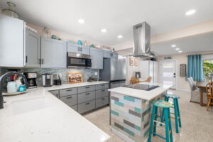Short term rental home updated kitchen withquartz and shells add to coastal vibe
